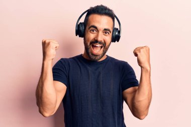 Kulaklıkla müzik dinleyen genç İspanyol adam gururla haykırıyor, zaferi kutluyor ve kollarını kaldırarak çok heyecanlanıyor. 