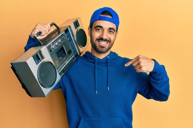 Kasetçalar tutan genç İspanyol adam, müzik dinlerken gülümseyen mutlu ve gururlu birini işaret ediyor. 