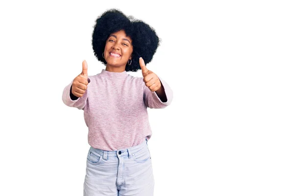 若いアフリカ系アメリカ人の少女は 手で積極的なジェスチャーを行うことを承認カジュアルな服を着て 親指を笑顔と成功のために幸せ 勝者のジェスチャー — ストック写真