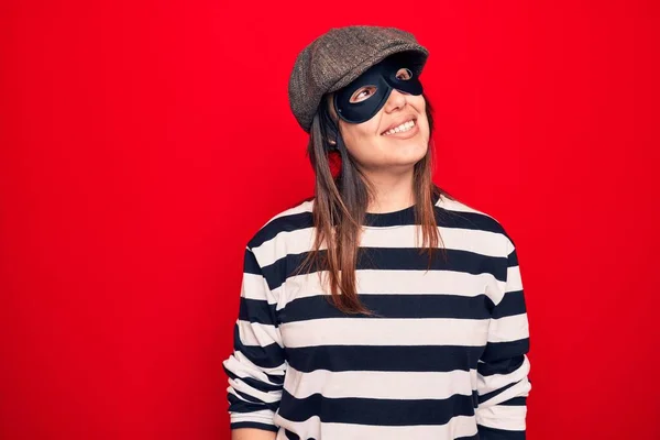 Young Beautiful Brunette Burglar Woman Wearing Cap Mask Isolated Red — Stock fotografie