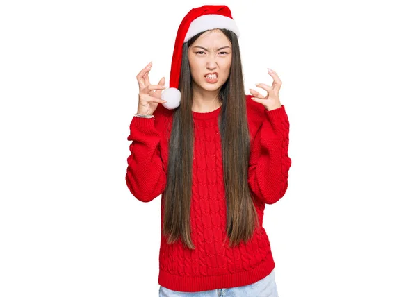 若い中国の女性は怒りでフラストレーションを叫んでクリスマスの帽子をかぶって 手は絞殺しようとし 怒って叫んで — ストック写真