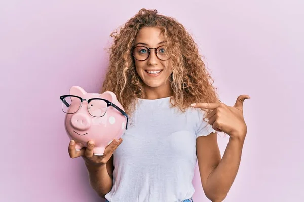 Mooi Kaukasisch Tiener Meisje Holding Piggy Bank Met Bril Wijzend — Stockfoto