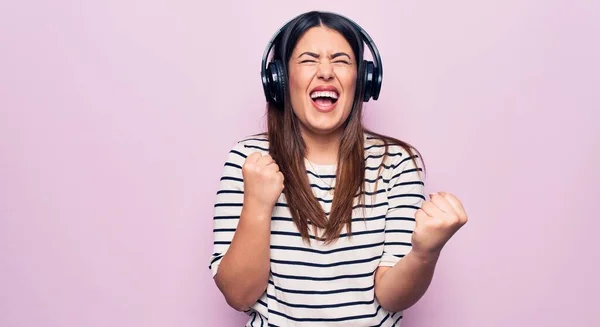 Young Beautiful Brunette Woman Listening Music Using Headphones Pink Background — Stock Photo, Image