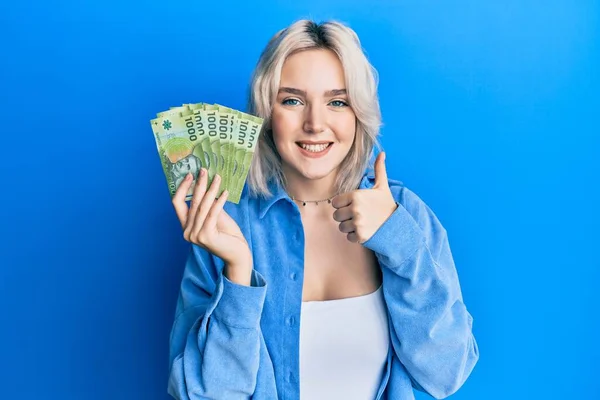 Mladá Blondýnka Drží 1000 Chilských Pesos Úsměvem Šťastný Pozitivní Palec — Stock fotografie