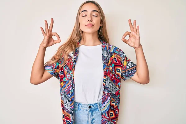 現代的な服を着て若い美しいブロンドの女性はリラックスし 指で瞑想ジェスチャーを行う目を閉じて笑顔 ヨガのコンセプト — ストック写真