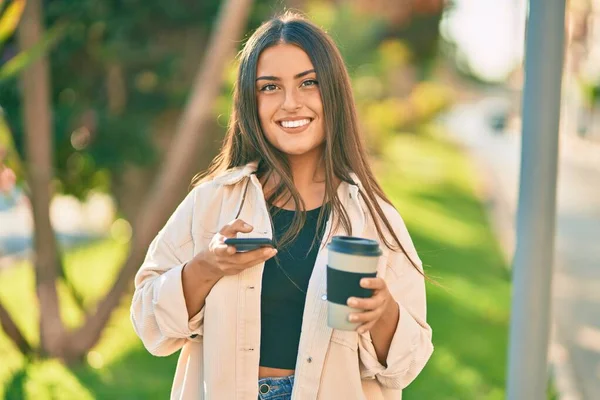 Junges Hispanisches Mädchen Lächelt Glücklich Mit Smartphone Und Trinkt Kaffee — Stockfoto