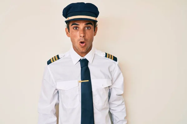 Joven Hombre Hispano Vistiendo Uniforme Piloto Avión Cara Choque Mirando —  Fotos de Stock