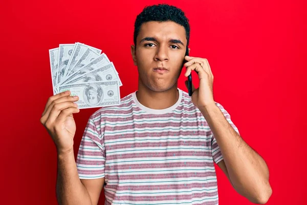 Hombre Árabe Joven Teniendo Conversación Hablando Teléfono Inteligente Sosteniendo Dólares —  Fotos de Stock