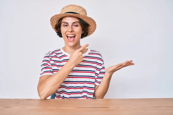 Jovem Hispânica Vestindo Roupas Casuais Chapéu Sentado Mesa Espantado Sorrindo — Fotografia de Stock