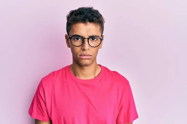 Jovem Afro Americano Bonito Vestindo Óculos Sobre Fundo Rosa Cético — Fotografia de Stock