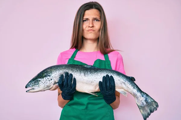 Beautiful Caucasian Woman Fishmonger Selling Fresh Raw Salmon Skeptic Nervous — Stock Photo, Image