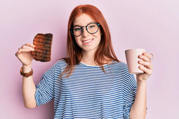 Joven Chica Pelirroja Sosteniendo Tostadas Quemadas Para Desayuno Sonriendo Con —  Fotos de Stock