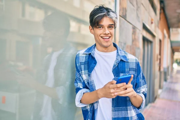 Joven Hombre Hispano Sonriendo Feliz Usando Smartphone Ciudad —  Fotos de Stock