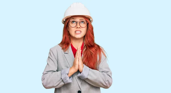 若い赤毛の女性の建築家のハードハット物乞いを着て手で祈ると一緒に顔に希望の表現は非常に感情的かつ心配 お願い — ストック写真