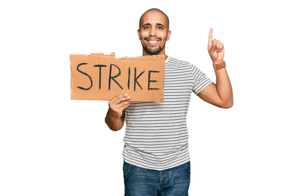 Hispanic Adult Man Holding Strike Banner Cardboard Surprised Idea Question — Stock Photo, Image