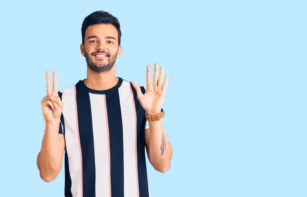 Genç Yakışıklı Çizgili Tişört Giyen Yedi Numaralı Parmaklarıyla Gösteriş Yapan — Stok fotoğraf
