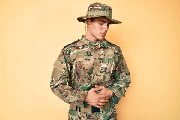 若いハンサムな男の胃の上に手でカモフラージュ軍の制服を着て消化不良 痛みを伴う病気の気分が悪い キャッシュ コンセプト — ストック写真