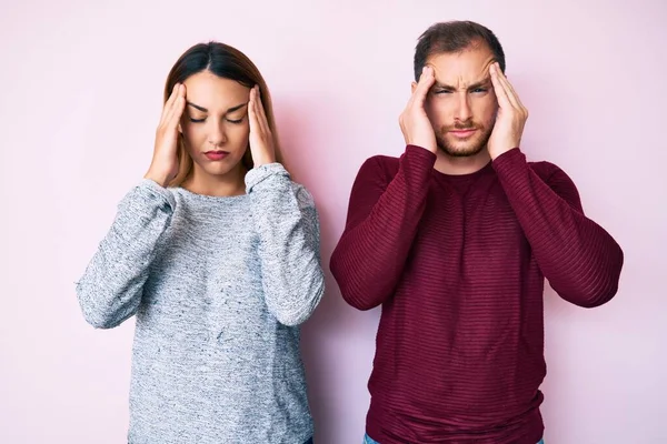 ストレスが原因で頭の痛みのために頭の上に手でカジュアルな服を着て美しいカップル 片頭痛 — ストック写真