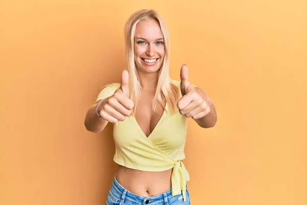 Młoda Blondynka Ubrana Luźne Ubrania Aprobująca Pozytywny Gest Ręką Kciuki — Zdjęcie stockowe