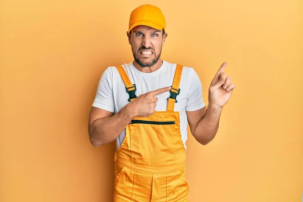 Jovem Bonito Homem Vestindo Handyman Uniforme Sobre Amarelo Fundo Apontando — Fotografia de Stock