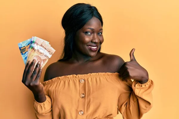 Africká Mladá Žena Drží Kanadské Dolary Úsměvem Šťastný Pozitivní Palec — Stock fotografie