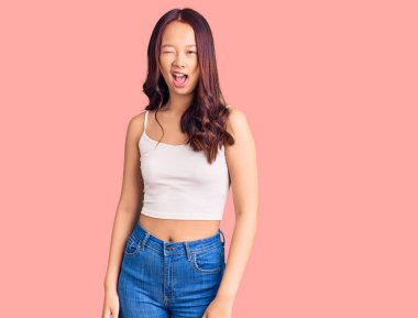 Genç, güzel Çinli bir kız. Günlük kıyafetler giyip kameraya bakıyor. Seksi bir ifadeyle, neşeli ve mutlu bir yüzle.. 