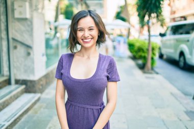 Genç ve güzel bir kız gülümsüyor. Mutlu bir şekilde yürüyor.