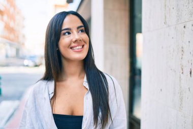 Genç İspanyol kız gülümseyerek şehirde mutlu mesut yürüyor..