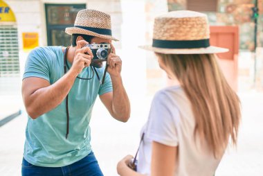 Genç bir çift erkek arkadaş ve kız arkadaş yaz gezisinde eski model kamera kullanarak fotoğraf çekiyorlar.
