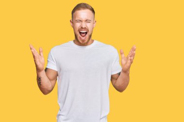 Genç İrlandalı sıradan kıyafetler giymiş çılgın ve çılgın başarıyı kutluyor kollarını kaldırmış ve gözlerini kapatmış heyecanlı çığlıklar atıyor. Kazanan konsept 