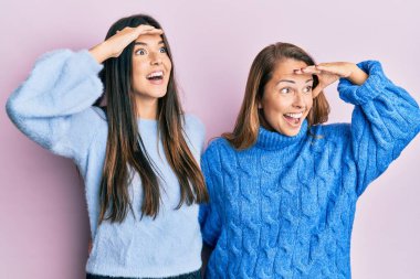 Anne-kız İspanyol ailesi yün kazak giyiyor çok mutlu ve tebessüm ediyor başlarını kaldırmış bakıyorlardı. arama kavramı. 