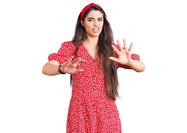 Yazlık elbise giyen esmer kız korku ifadesinden korkmuş ve dehşete düşmüş. El hareketlerini durdur, şok içinde bağır. panik konsepti. 