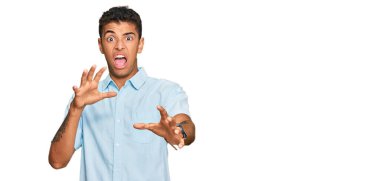 Genç, yakışıklı, Afro-Amerikan bir adam günlük kıyafetler giyiyor. Korkudan dehşete düşmüş ve korkmuş bir ifade. El hareketlerini durdur, şok içinde bağır. panik konsepti. 