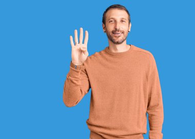 Genç, yakışıklı, günlük kıyafetler giyen, dört numarayı gösteren ve gülümseyen, kendinden emin ve mutlu bir adam.. 