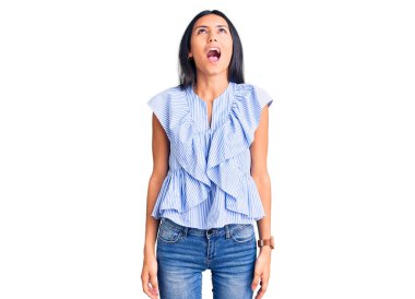 Genç, güzel, latin bir kız, günlük kıyafetler giyiyor kızgın ve kızgın bağırıyor, sinirlenmiş ve öfkeli, öfkeyle bağırıyor. öfke ve agresif konsept. 