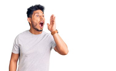 Yakışıklı Latin Amerikalı genç adam gündelik tişört giyip el ele tutuşarak bağırıyor ve bağırıyordu. iletişim konsepti. 