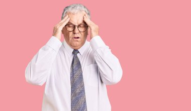 Yaşlı, gri saçlı, iş kıyafetleri giyen, başı ağrıyan bir adam, stres yüzünden. migren ağrısı. 