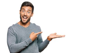 Yakışıklı İspanyol adam gündelik giysiler giyip kameraya hayret ediyor ve gülümsüyor.. 