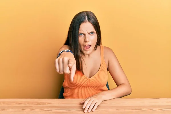 Ung Kaukasiska Kvinna Klädd Casual Kläder Sitter Bordet Pekar Missnöjd — Stockfoto