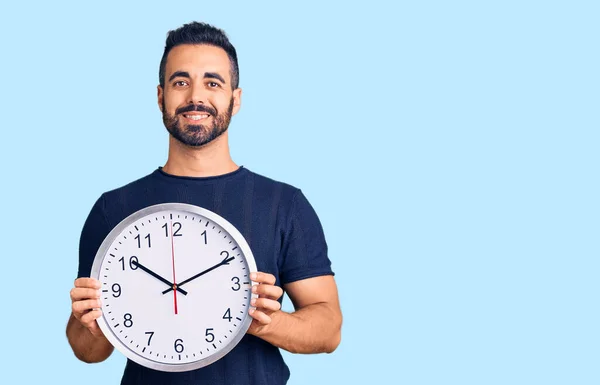 Jovem Hispânico Homem Segurando Grande Relógio Olhando Positivo Feliz Sorrindo — Fotografia de Stock