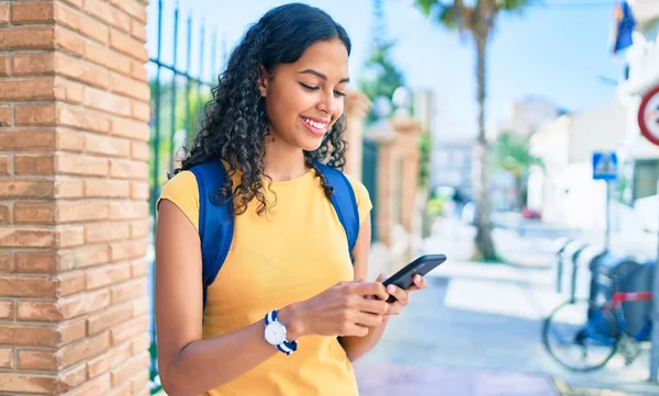 大学のキャンパスでスマートフォンを使う若いアフリカ系アメリカ人の学生の女の子 — ストック写真