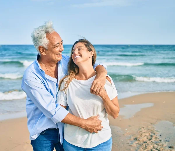 Pareja Hispana Mediana Edad Sonriendo Feliz Abrazándose Caminando Playa —  Fotos de Stock