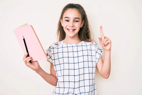 Nettes Hispanisches Kindermädchen Mit Buch Und Bleistift Überrascht Mit Einer — Stockfoto