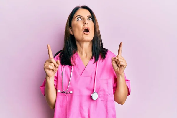 Middle Age Brunette Woman Wearing Doctor Uniform Stethoscope Amazed Surprised — Stock Photo, Image