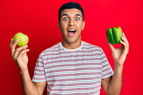 Young Arab Man Holding Green Apple Pepper Celebrating Crazy Amazed — Stock fotografie