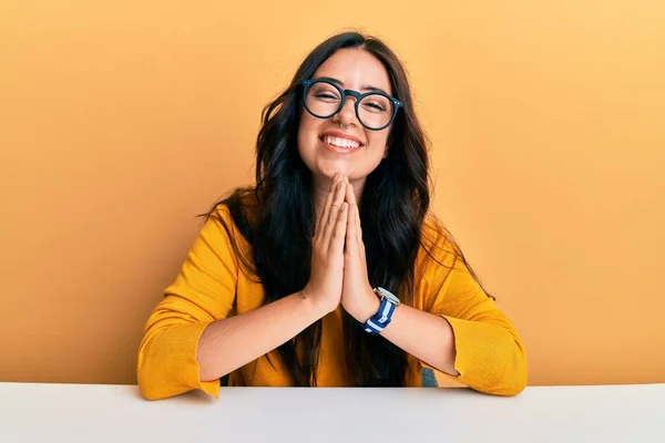 Hermosa Morena Joven Con Gafas Ropa Casual Sentada Mesa Rezando —  Fotos de Stock