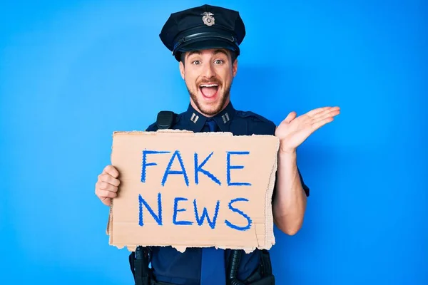 Young Caucasian Man Wearing Police Uniform Holding Fake News Banner — Stock fotografie