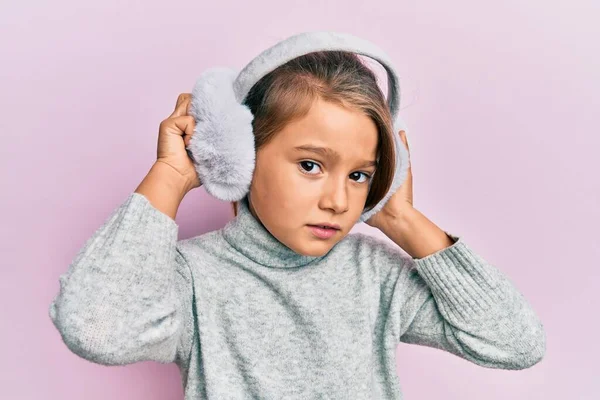 Kleine Schöne Mädchen Tragen Flauschige Ohrenschützer Skeptisch Und Nervös Stirnrunzeln — Stockfoto