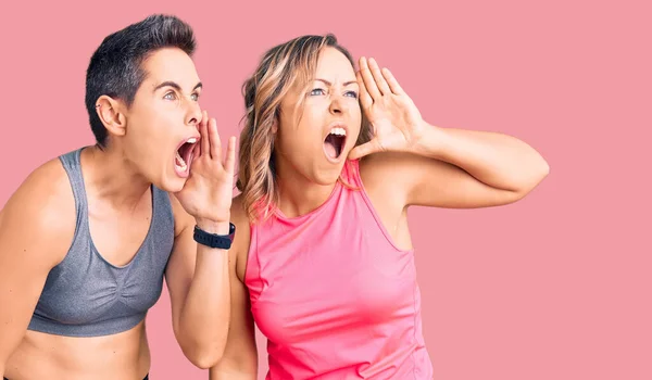 Couple Women Wearing Sportswear Shouting Screaming Loud Side Hand Mouth — Stock Photo, Image