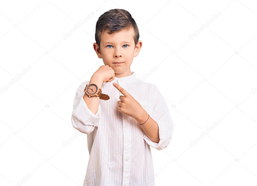 Cute blond kid wearing elegant shirt in hurry pointing to watch time, impatience, looking at the camera with relaxed expression 